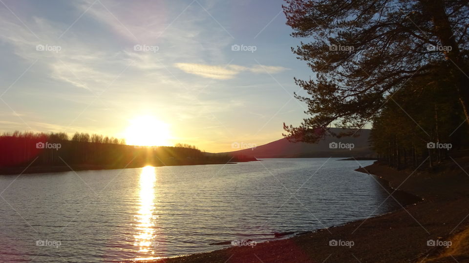 sunset on a reservoir and mountains in the Urals in Russia
