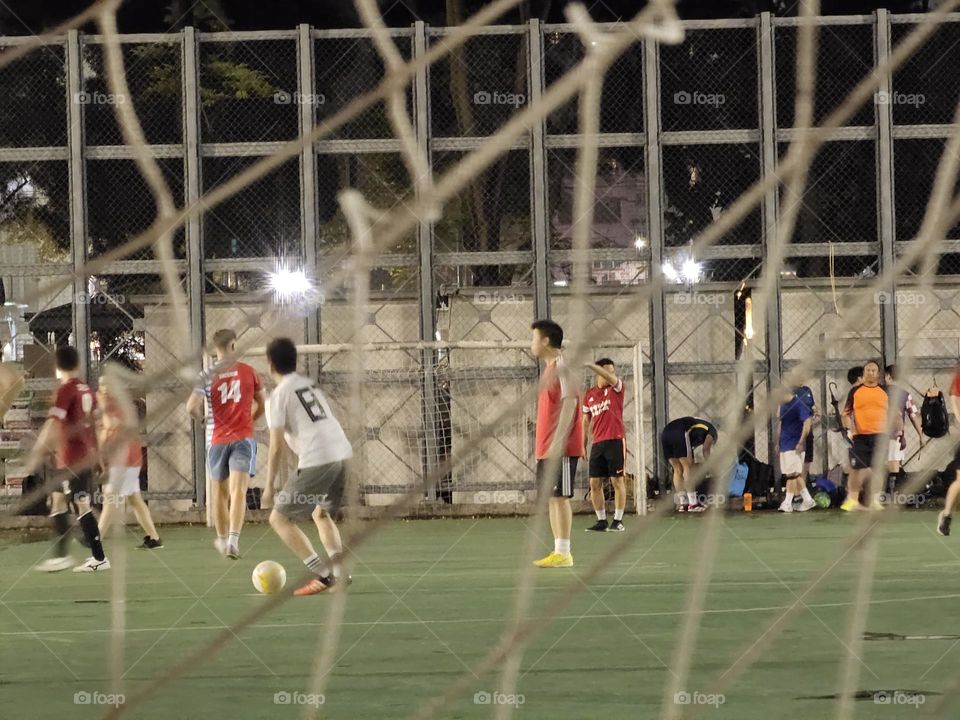 Men playing soccer after the rain at Hong Kong Victoria Park