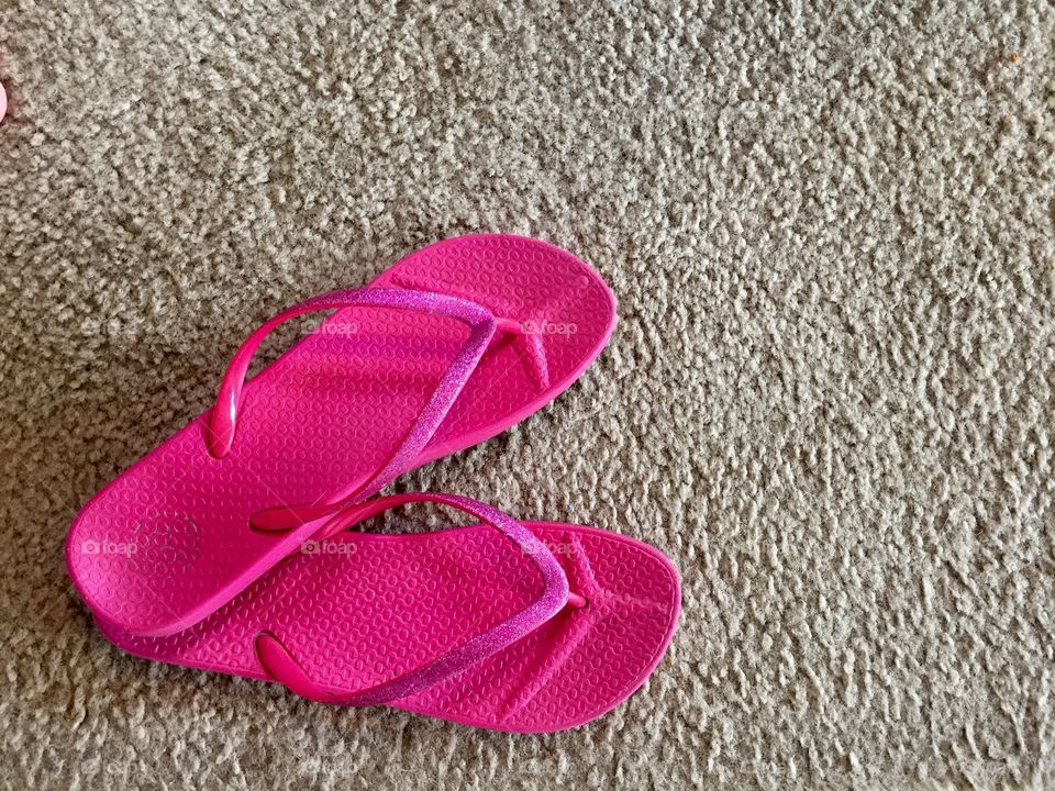 Pink flip-flop on carpet