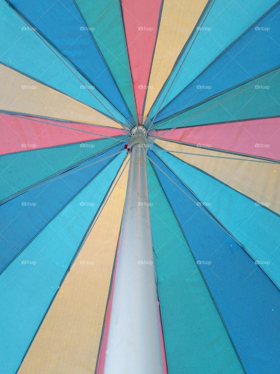 Bright and colorful umbrella to help shade a sunny pool day