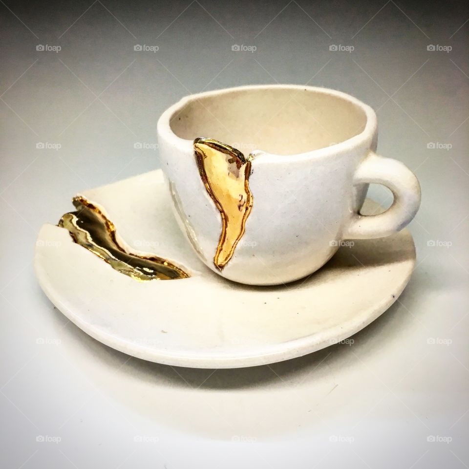 Imperfect teacup and saucer patched with gold 