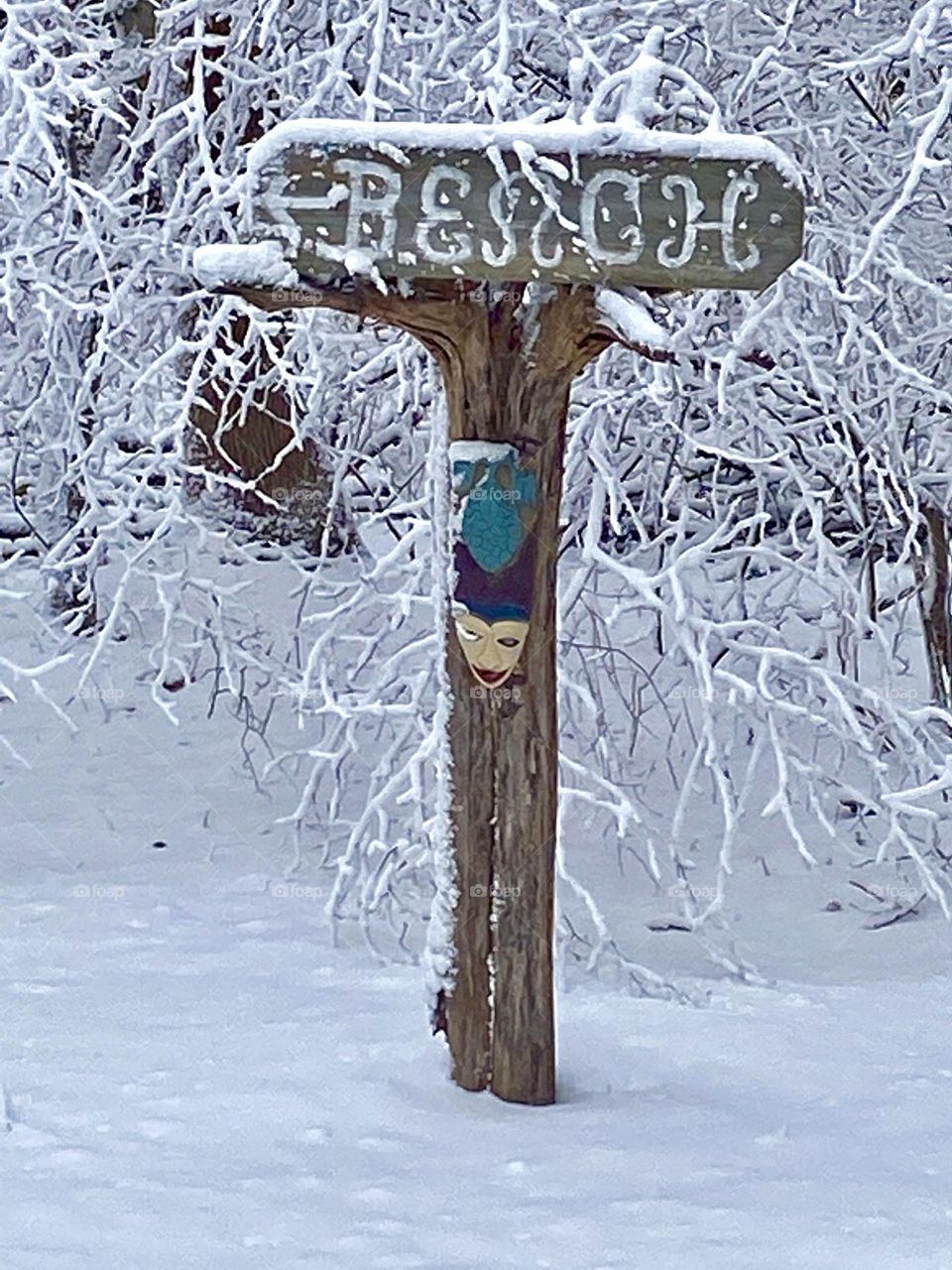 Snow covered beach sign