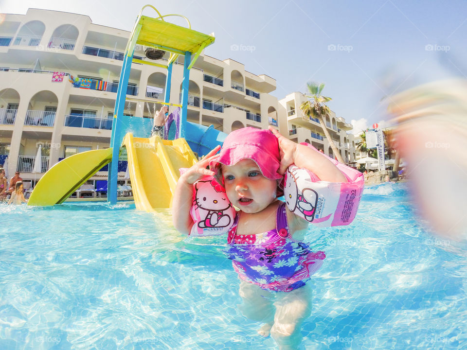 Little two year old girl playing in the pool on her holiday at Alcudia Pins on Majorca.