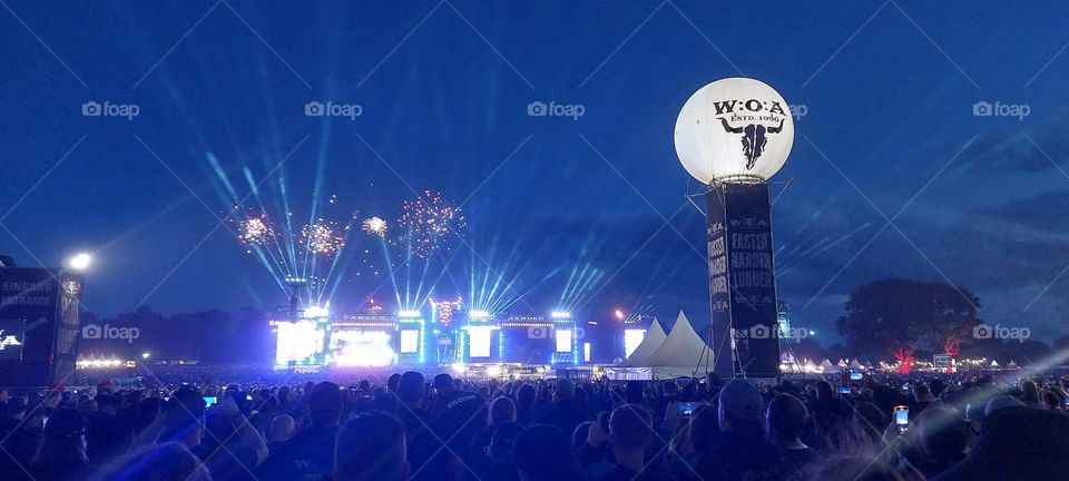 Festival mood. Wacken Open Air fireworks show. Huge scene lights