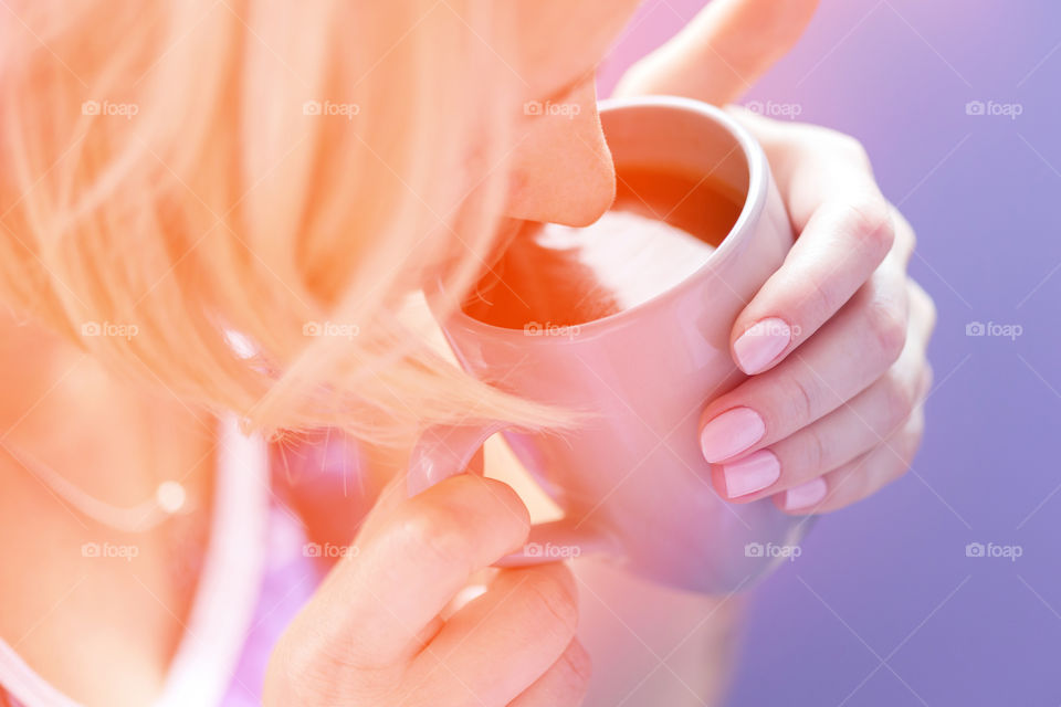 Young woman drinking hot aromatic tea in the morning