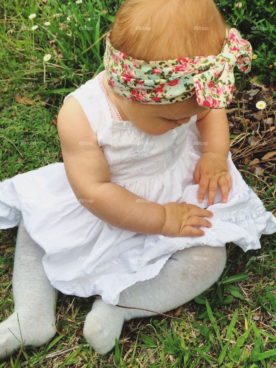 Baby girl fixing her pretty little dress 