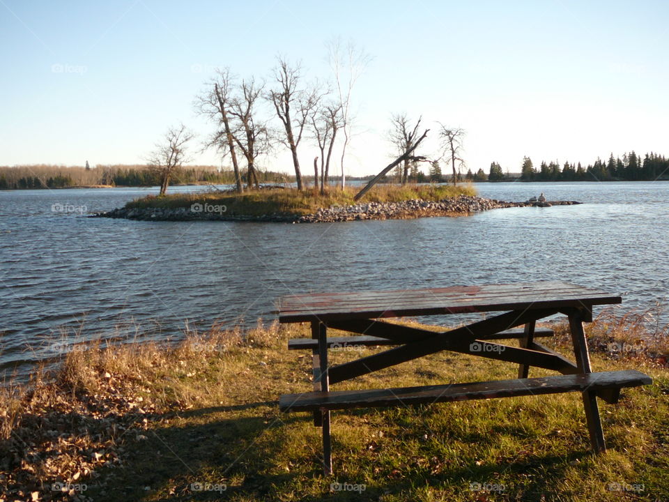 Empty bench near lake