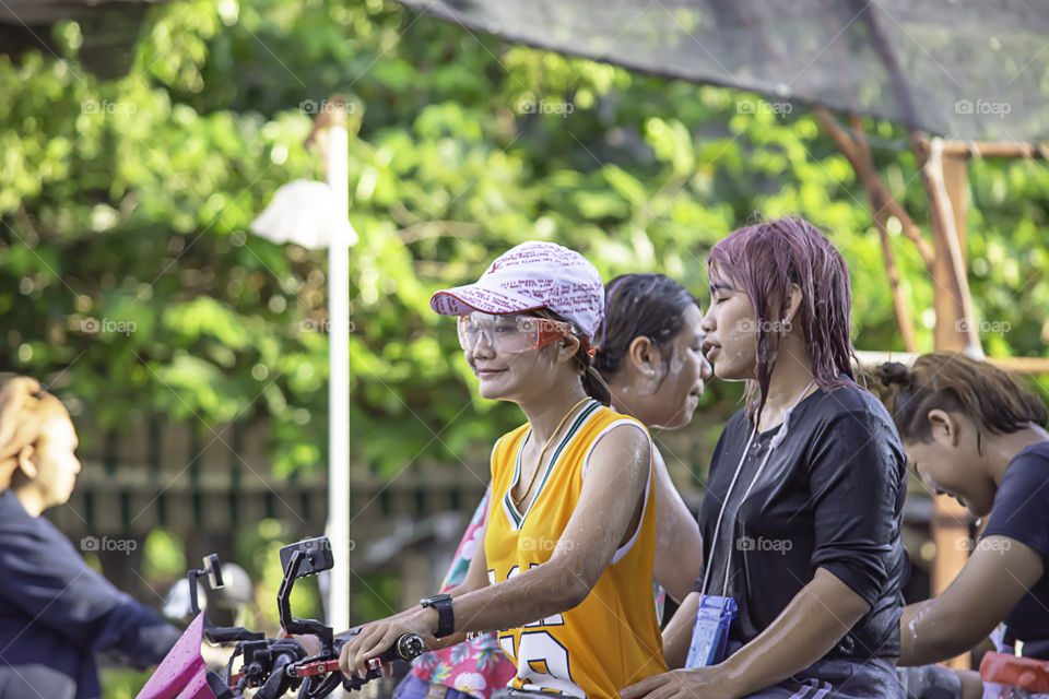 Asian woman Riding a motorcycle play water and flour in Songkran festival or Thai new year in Thailand at Bang kruai, Nonthaburi , April 15, 2019