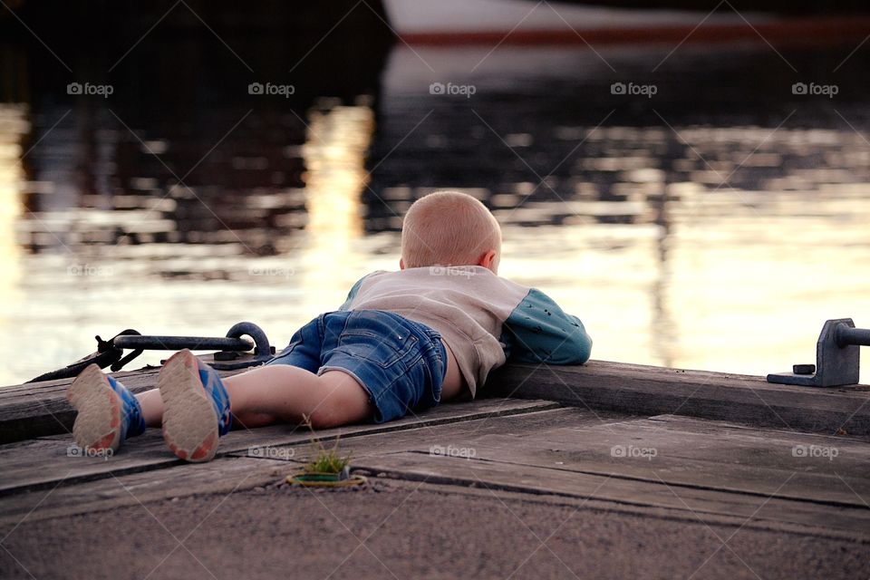 Boy looks down to see fishes