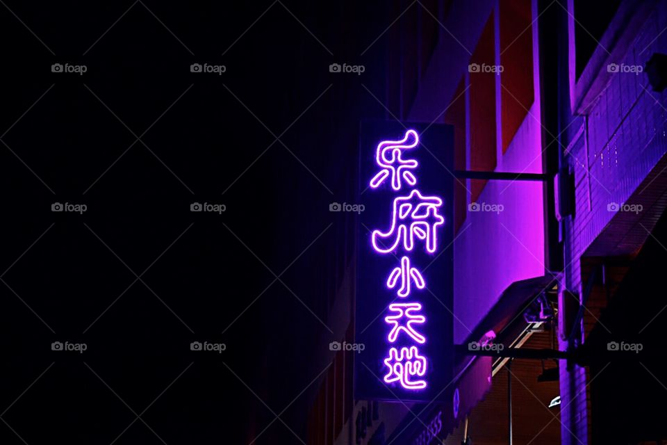 Bar sign illuminates a dark alleyway deep in the urban jungle of Singapore