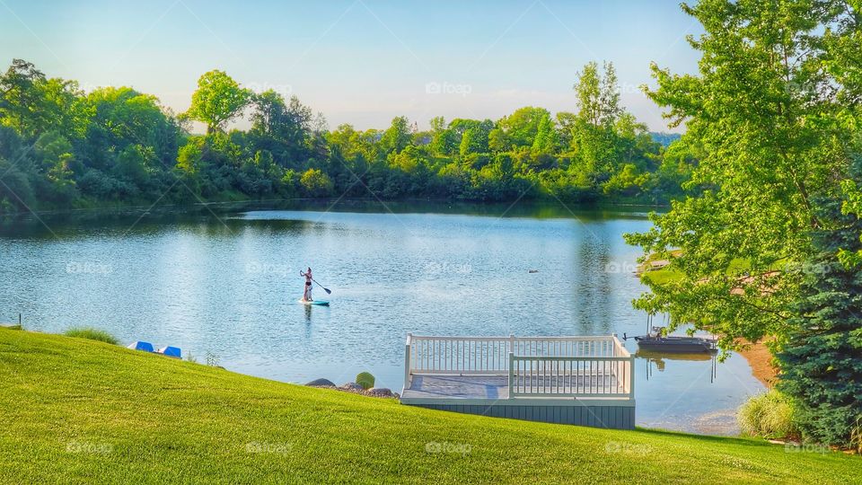minimalist paddleboarder with dog on lake