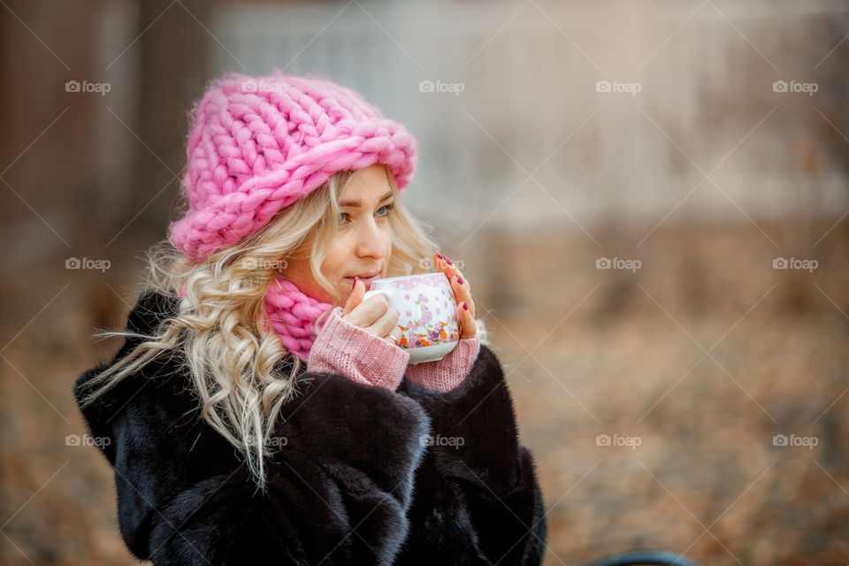 Outdoor Portrait of blonde woman in pink crochet accessories 