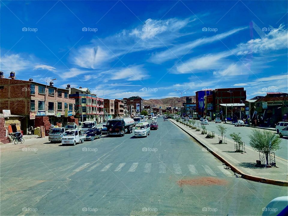 This is a small town near the “Uniyuni Salt Lake” in “Bolivia” in “Central America”. The center square is surrounded by various buildings while cars keep on driving by on the main road. 2022. Hypnotic Productions