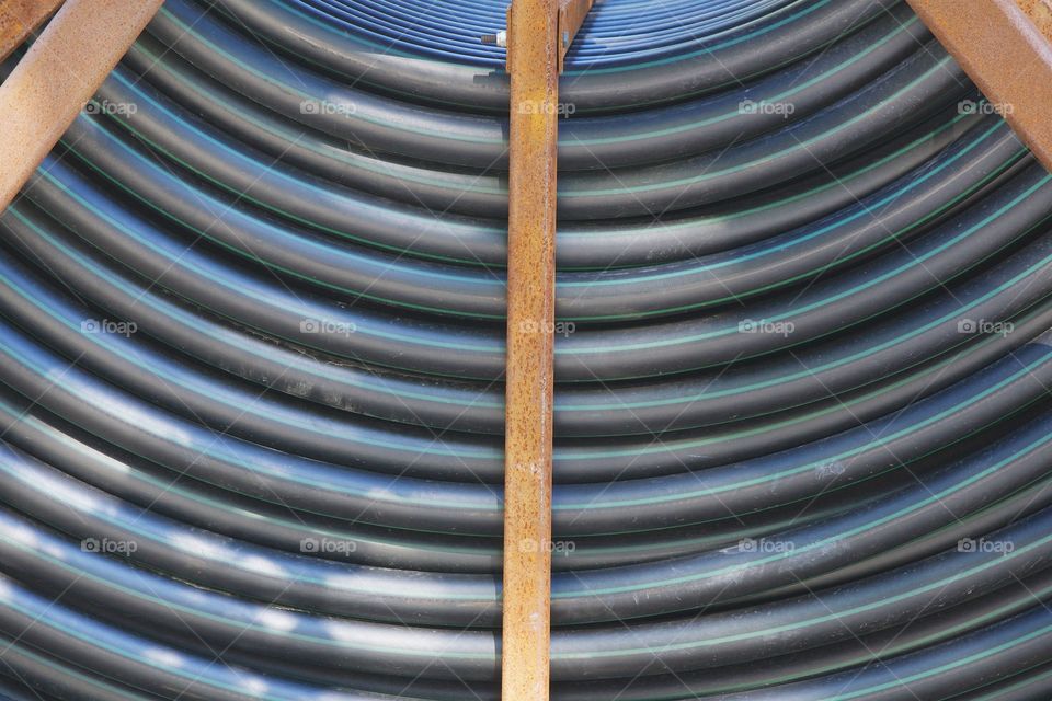 A closeup symmetrical abstract of an underground tubing spool on a truck parked at a construction on the street in Brooklyn, New York City.