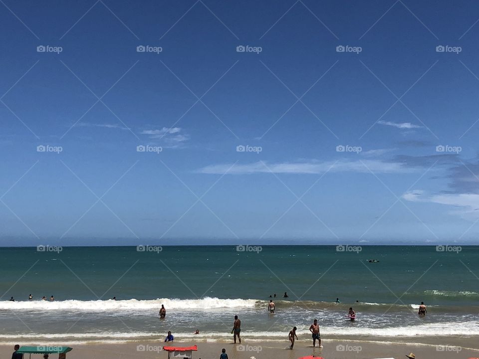 Relaxing in the beach...  A clear, summer day. The sea is calm, with some waves to play. A great summertime vacation!