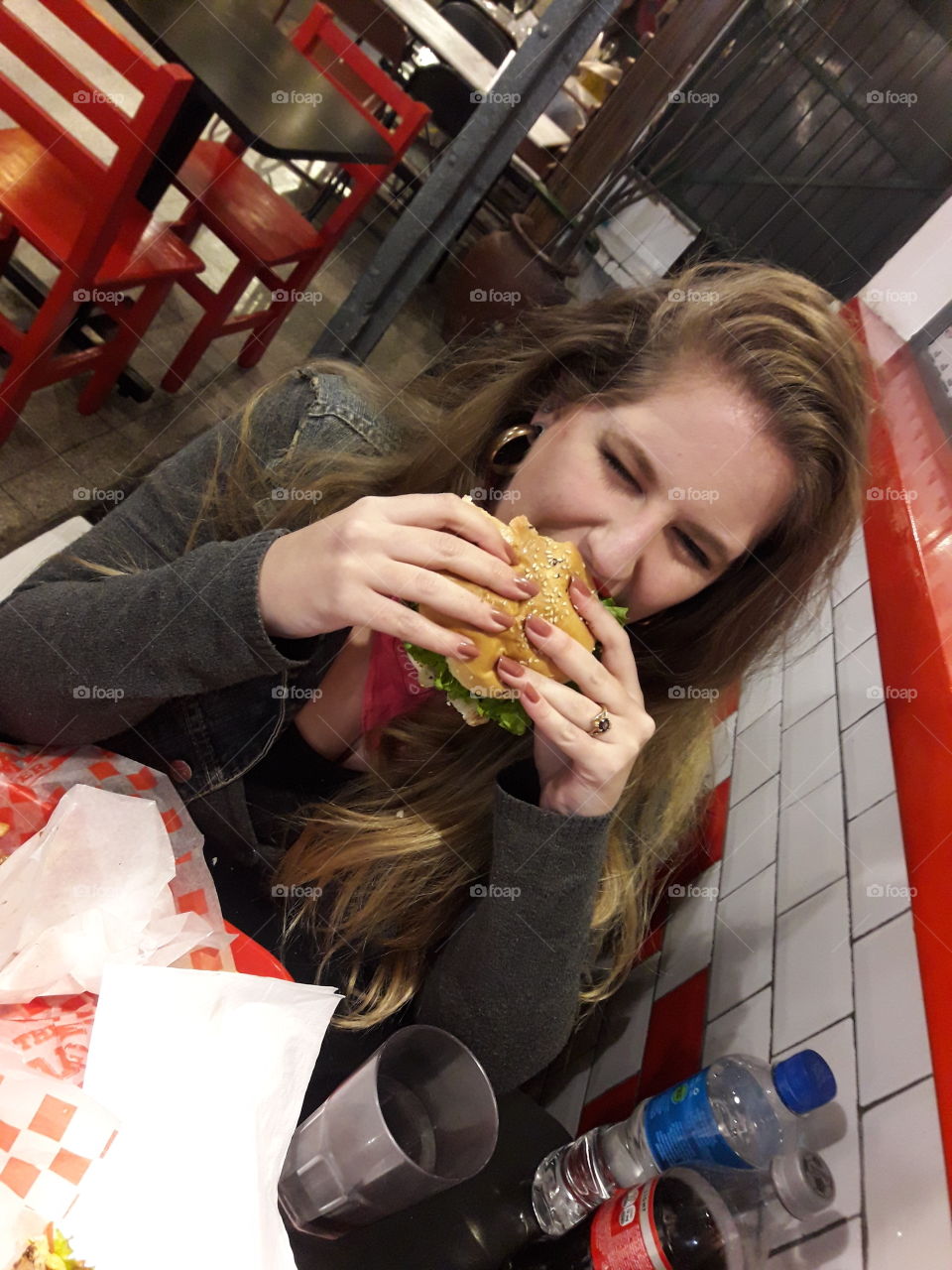 Silly girl taking a big bite of a burger