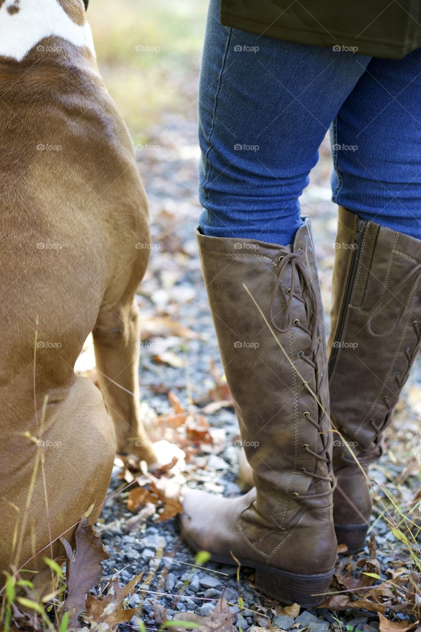A Girl’s Best Friend; Woman in knee high back tie boots and jeans with her Boxer.