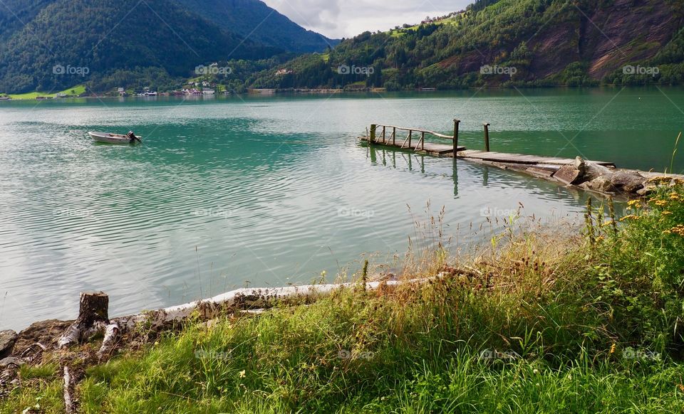 Beautiful view of water and wood jetty on the Lustrafjord in Norway