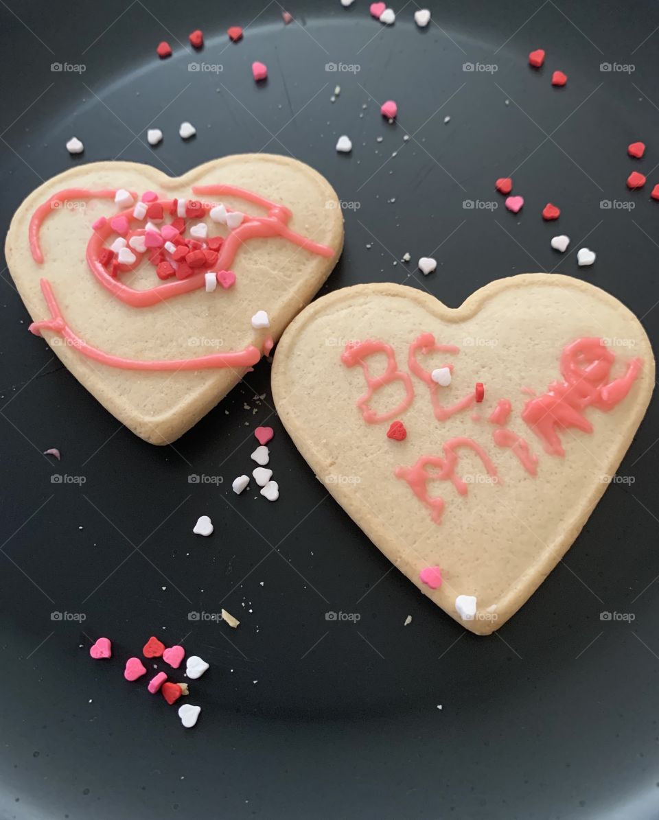 Valentine’s Day heart shaped sugar cookies decorated with pink and red frosting. 