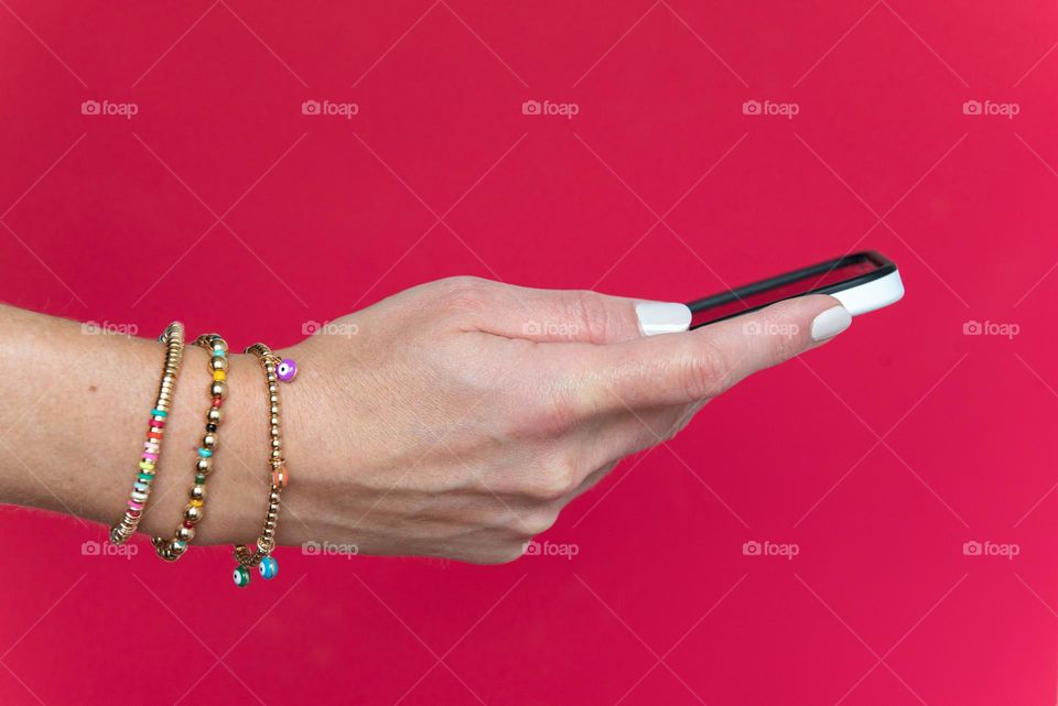 Colorful closeup of a woman’s hand holding a smartphone 