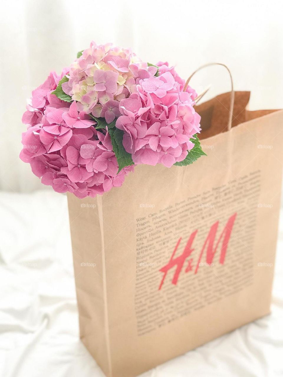 A shopping bag full of beautiful clothes and beautiful flowers