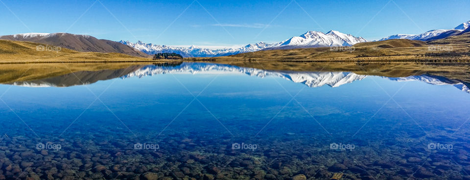 Snowy mountain reflected on lake