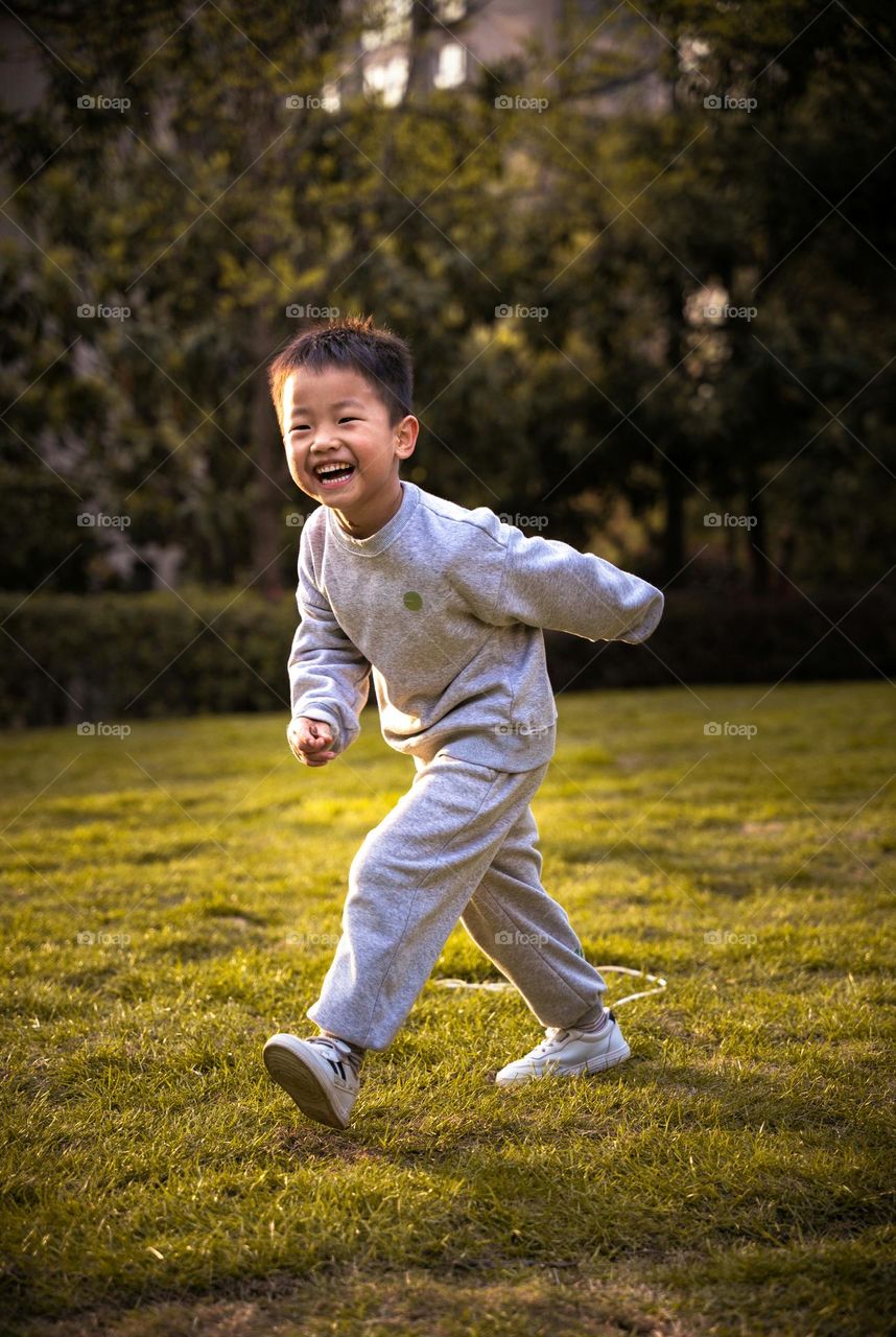 A kid was captured while he was playing and running around. He puts smile on his face as he noticed me.