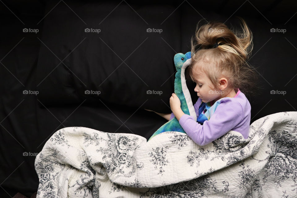 Young child sleeping with her stuffed animal