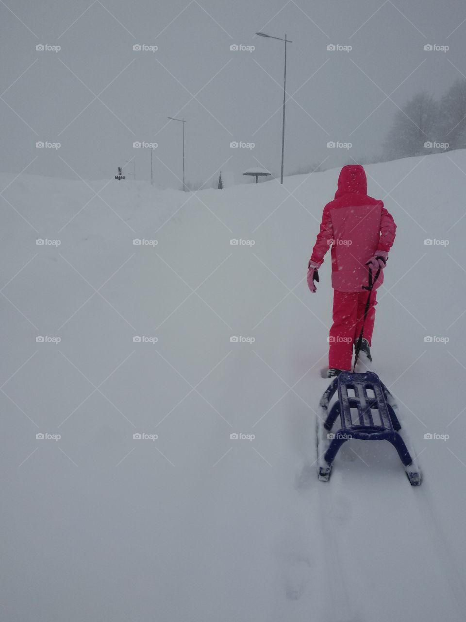 Young girl with snow sledge