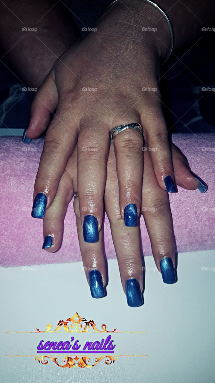 nail client with false tips and gel overlay blue cateye gel polish