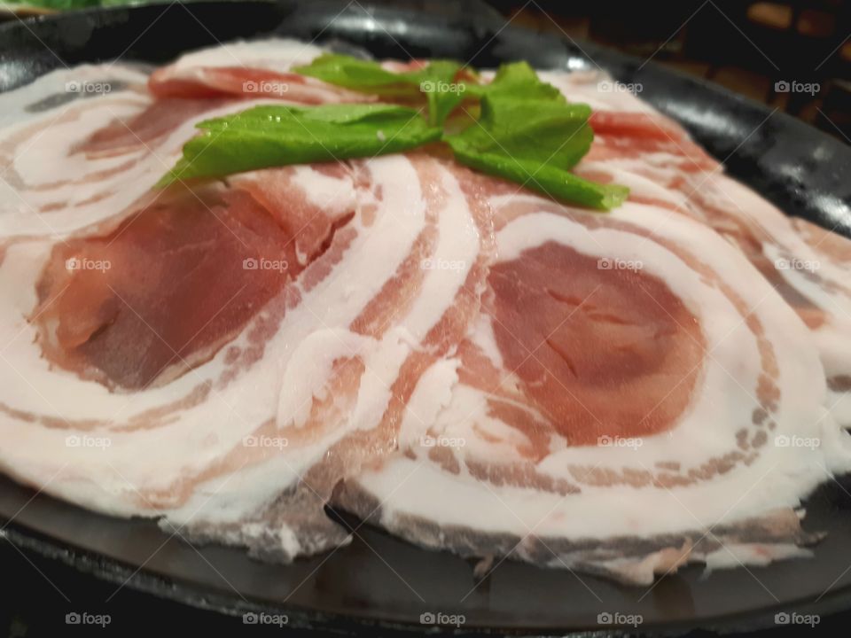 Raw meat , pork sliced on black plate