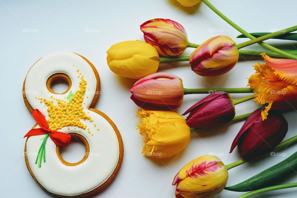 8 March gingerbread and colorful tulips on a white background women's day