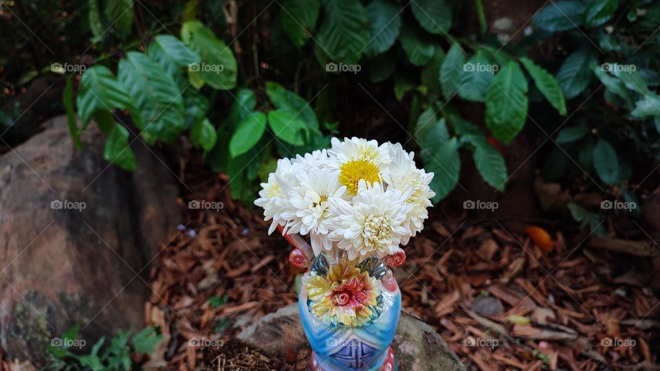 Beautiful white flowers in a colourful flowerpot with a flower sculpture, Flowers in a vase, colourful vase, white flowers in a vase