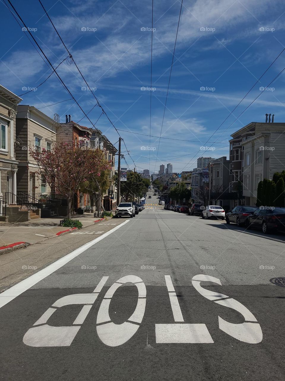View looking towards downtown San Francisco on union Street California, very calm almost deserted, with the word stop painted on the street in the foreground 
