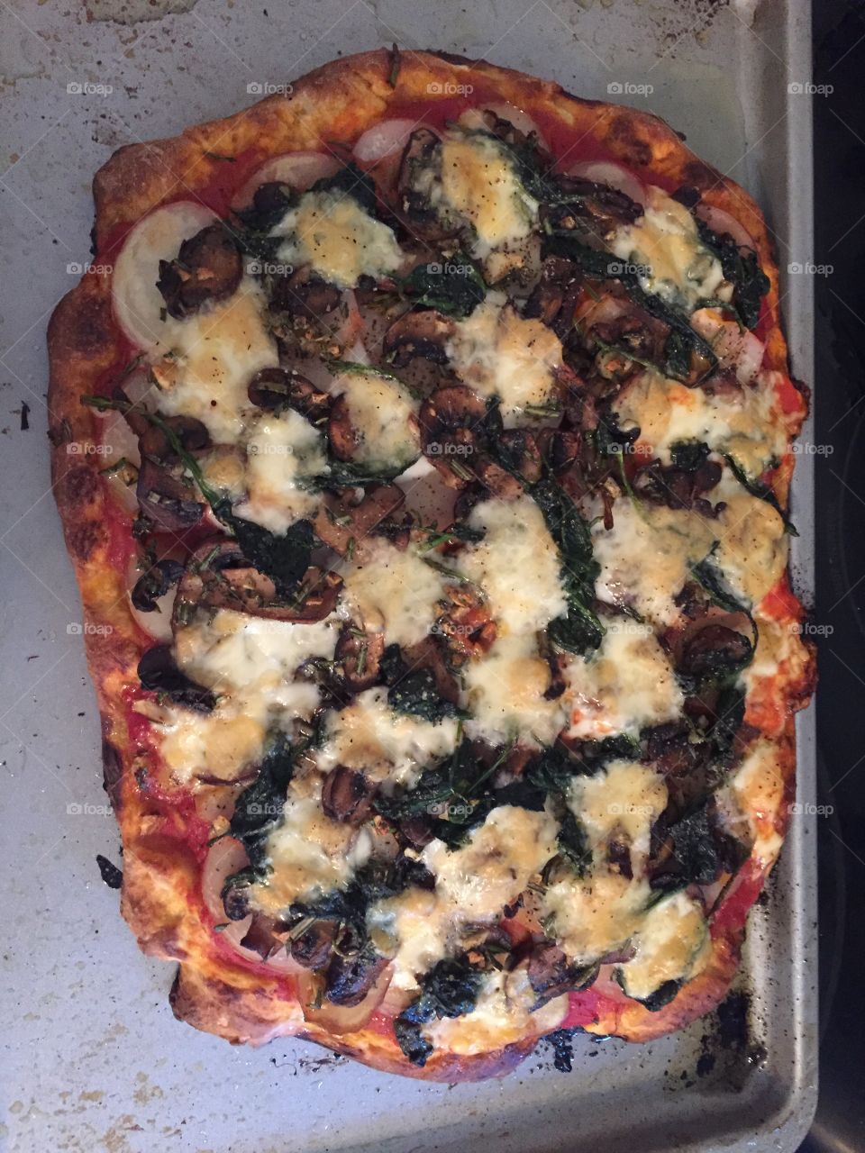Non-traditional homemade pizza, delicious with potatoes, mushrooms, cheese, sauce, and spinach