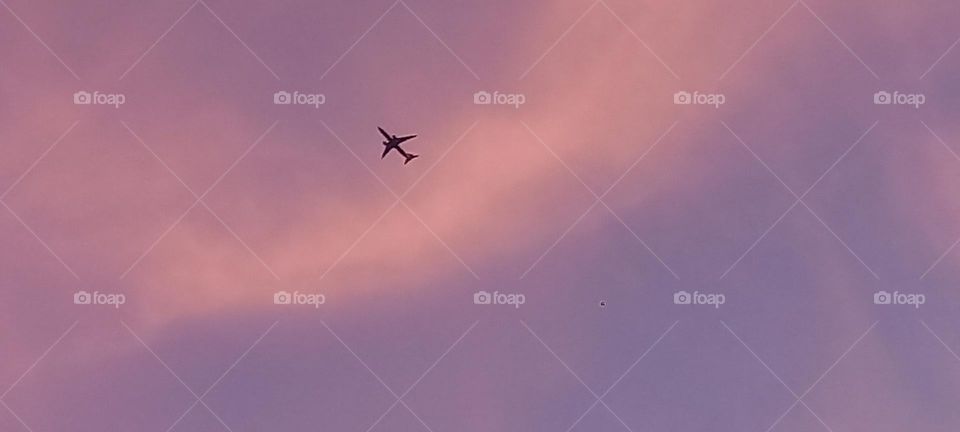 Avión comercial sobre cielo morado