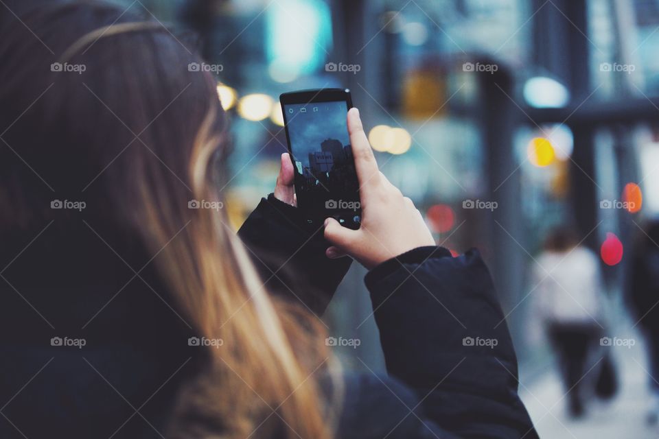 A young woman using her phone on the go