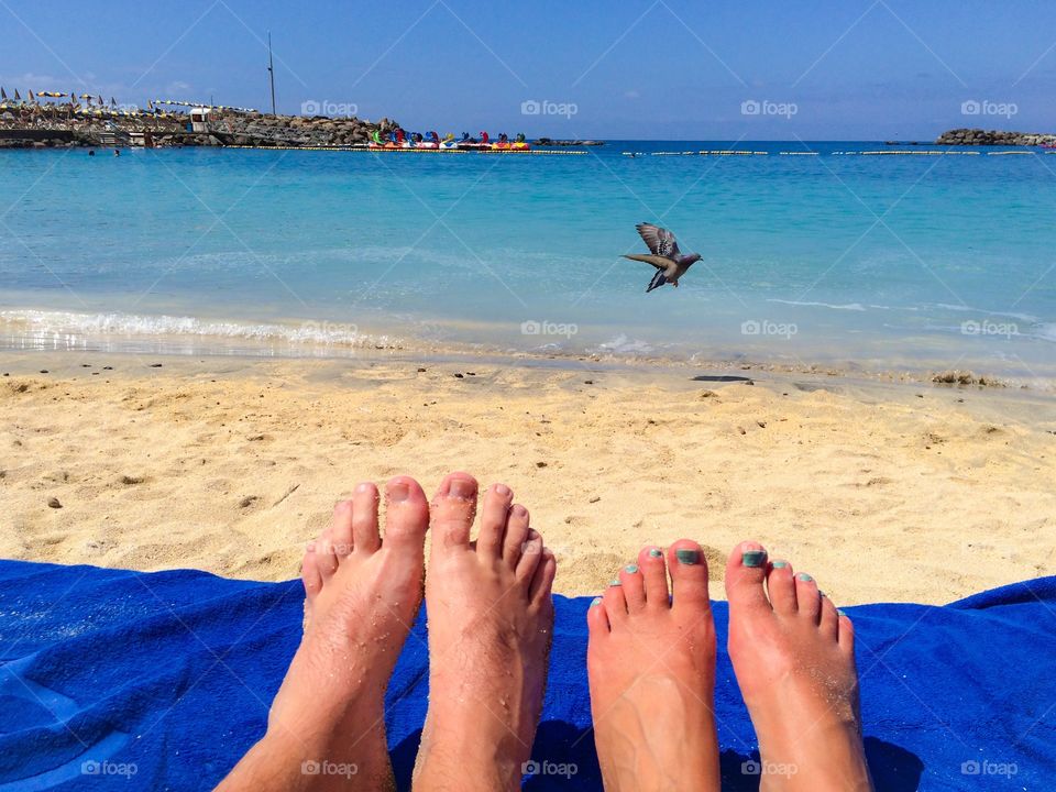 Low section view of couple stiiing on beach