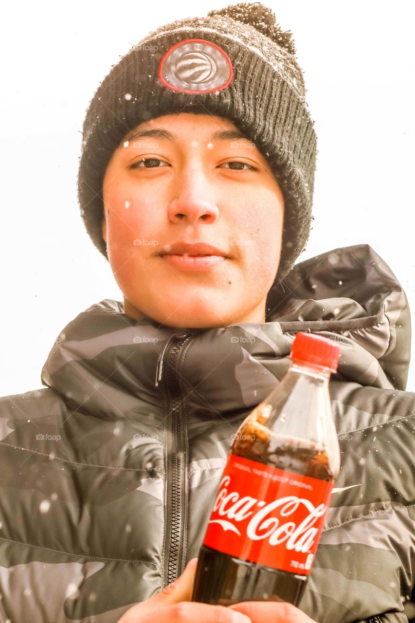 Happy teenager with a bottle of coca cola