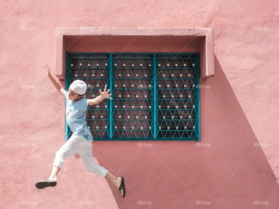 A boy joyous jumping on his way to the mosque