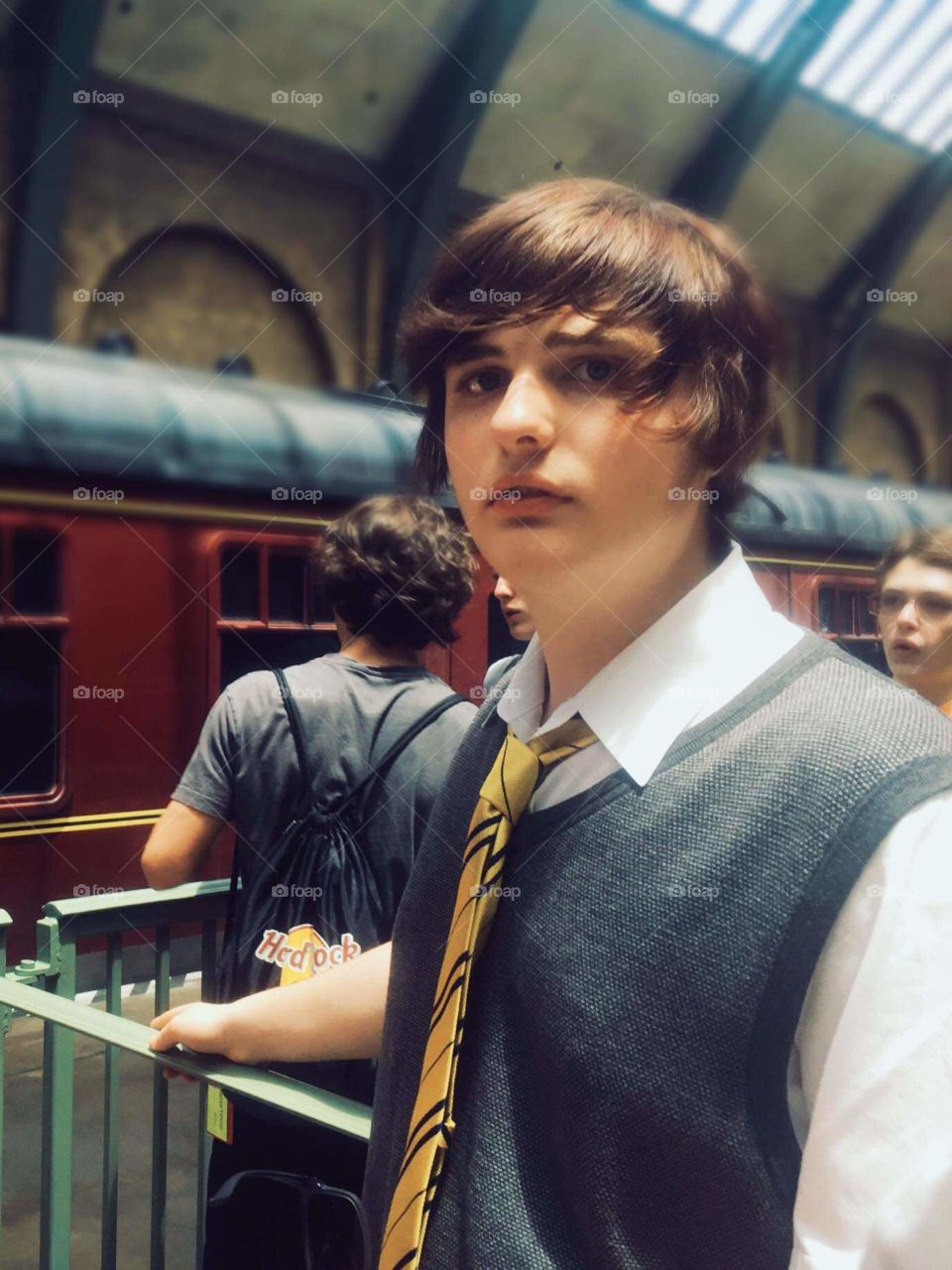 Young Man waiting at the train station at Universal Florida Harry Potter World. 