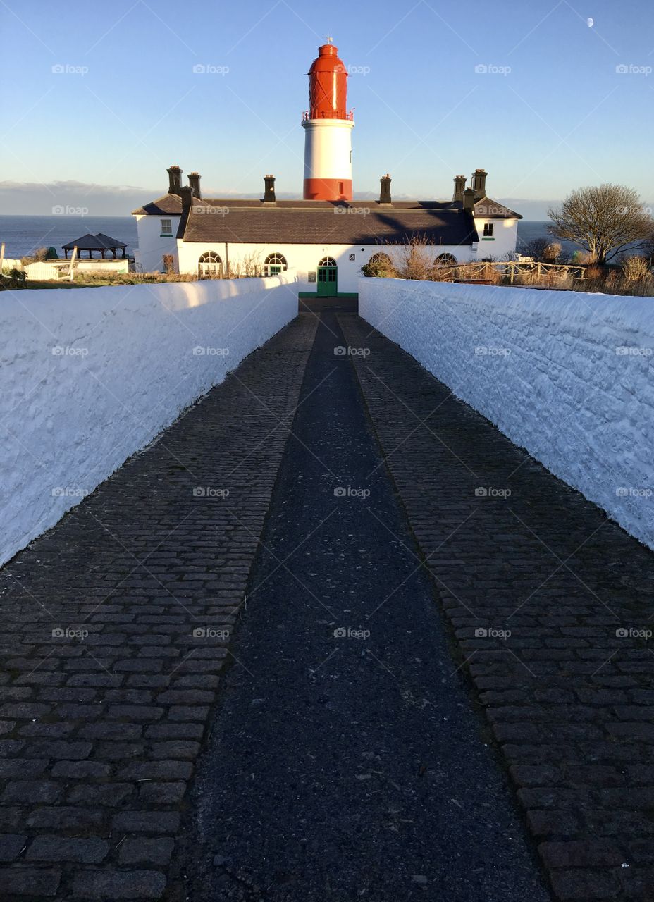 Red and White lighthouse against a blue sky background ... 