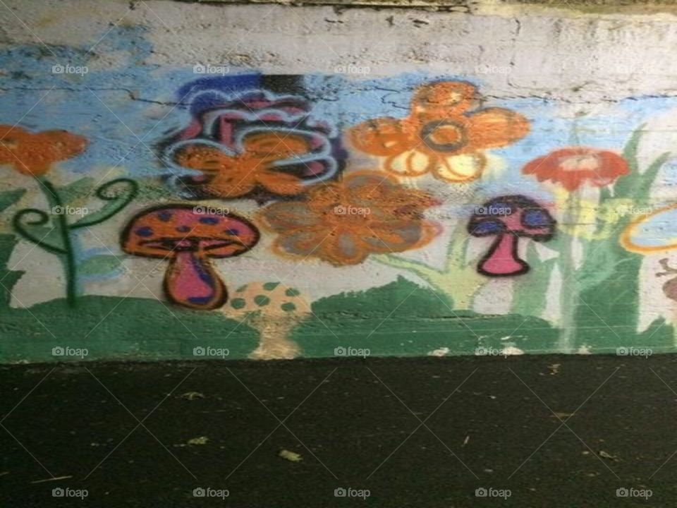 Mystical and possibly nostalgic graffiti litters the walls of an underpass of a bridge.