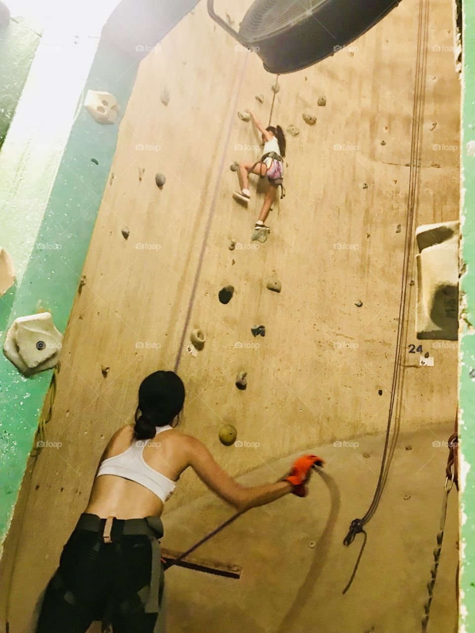 Wife and daughter indoor rock climbing