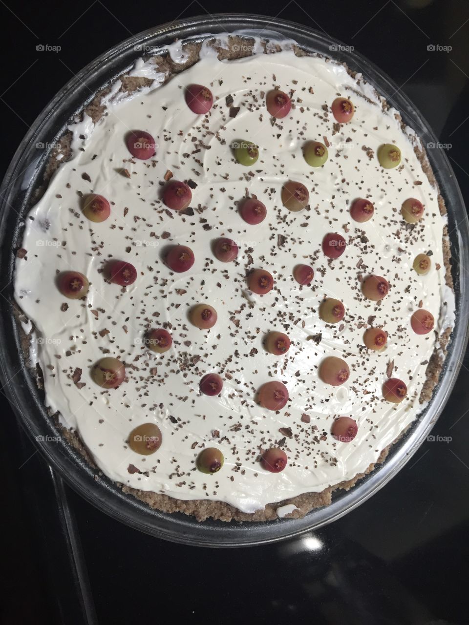 Keto cheesecake topped with pink lemonade blueberries and ground cocoa beans