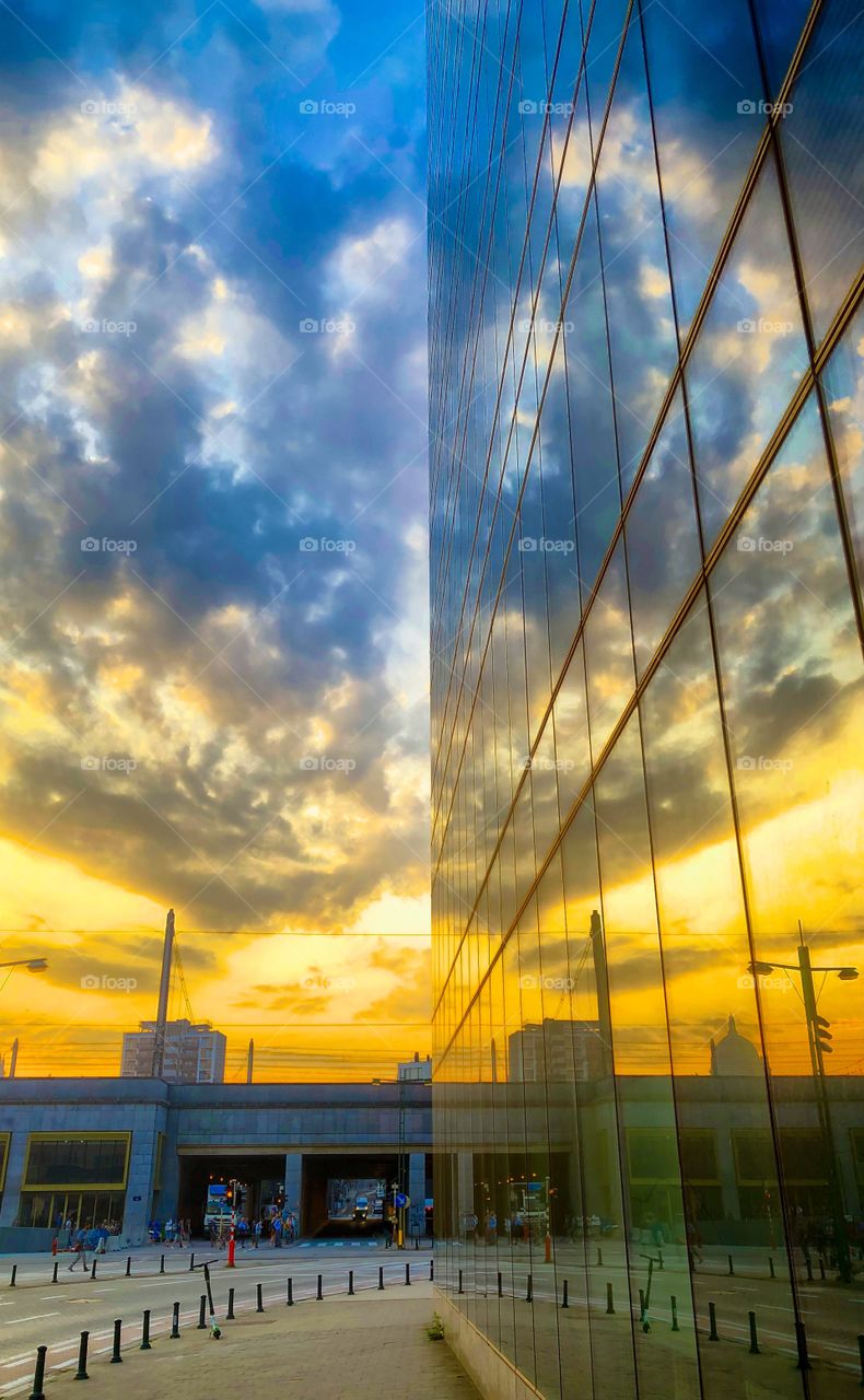Dramatic and colorful Golden blue sunrise reflected in the office windows of a corporate building in the business district of the city of Brussels 