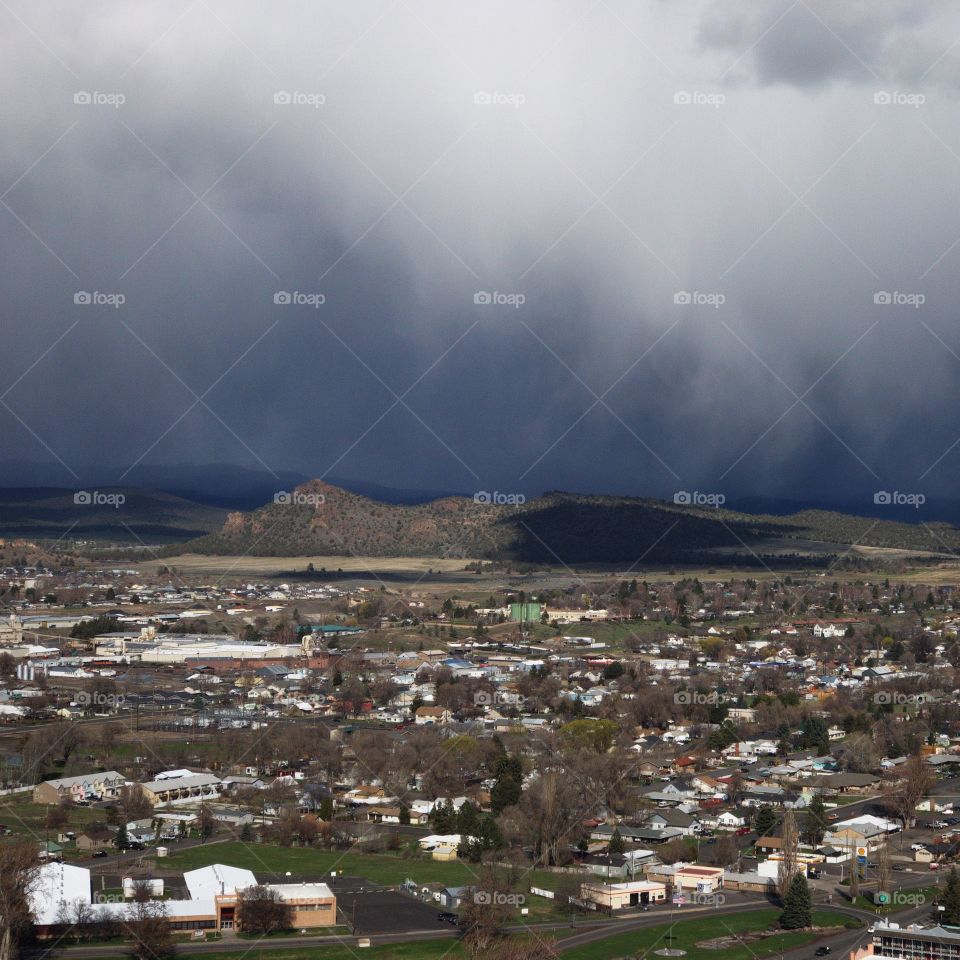 View from the Ochoco State Scenic Viewpoint of the town of Prineville, home of a growing technology sector, in Central Oregon with an intense sky from a rainstorm passing through. 