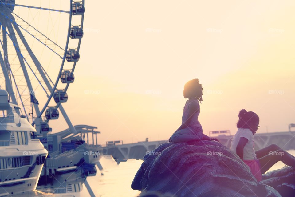 Sun Child. A girl enjoys the sunset at an outdoor structure near the River. 