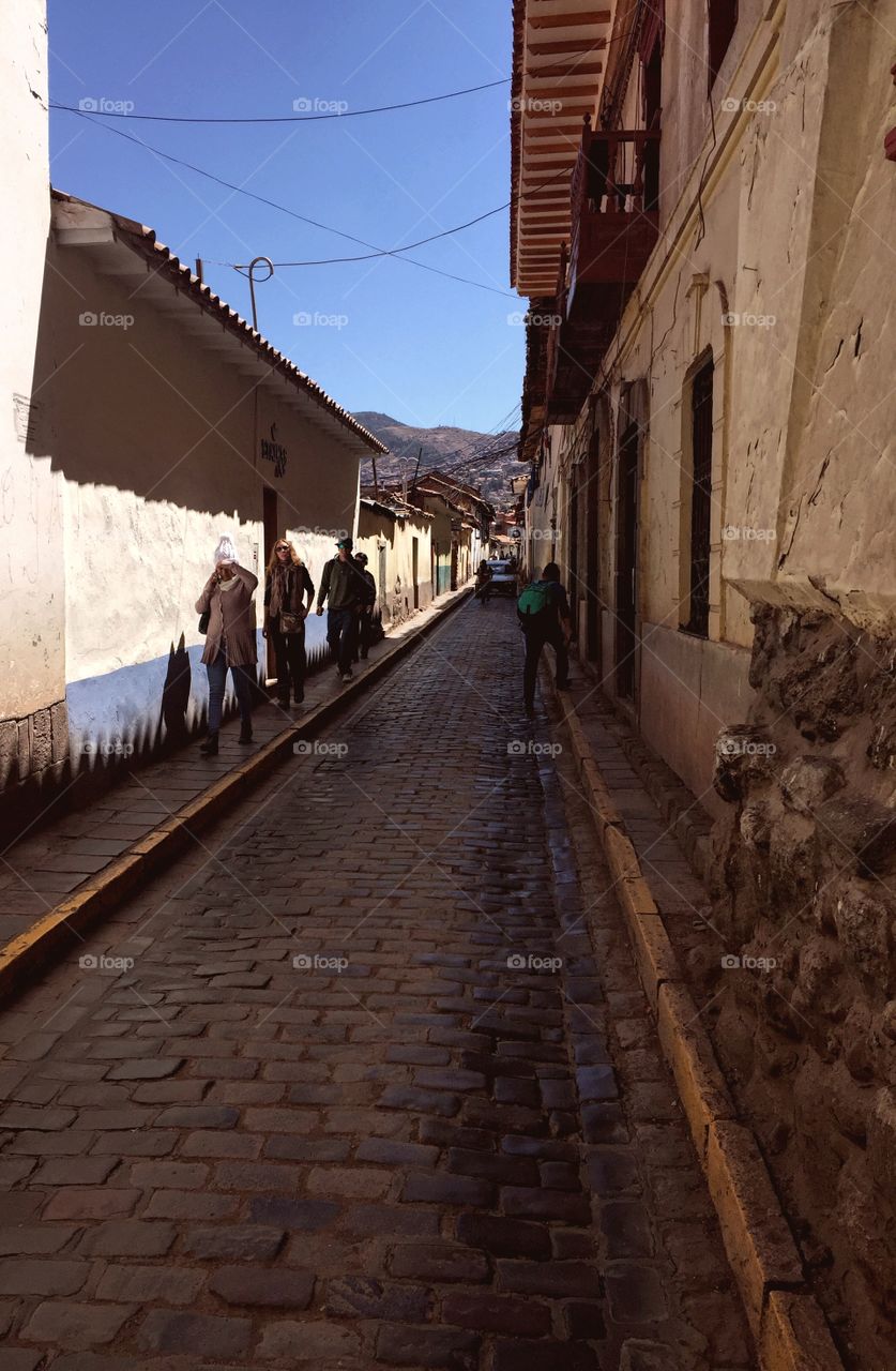 People walking down an ancient road in Cusco Peru