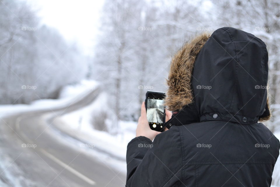 Rear view of woman taking photograph